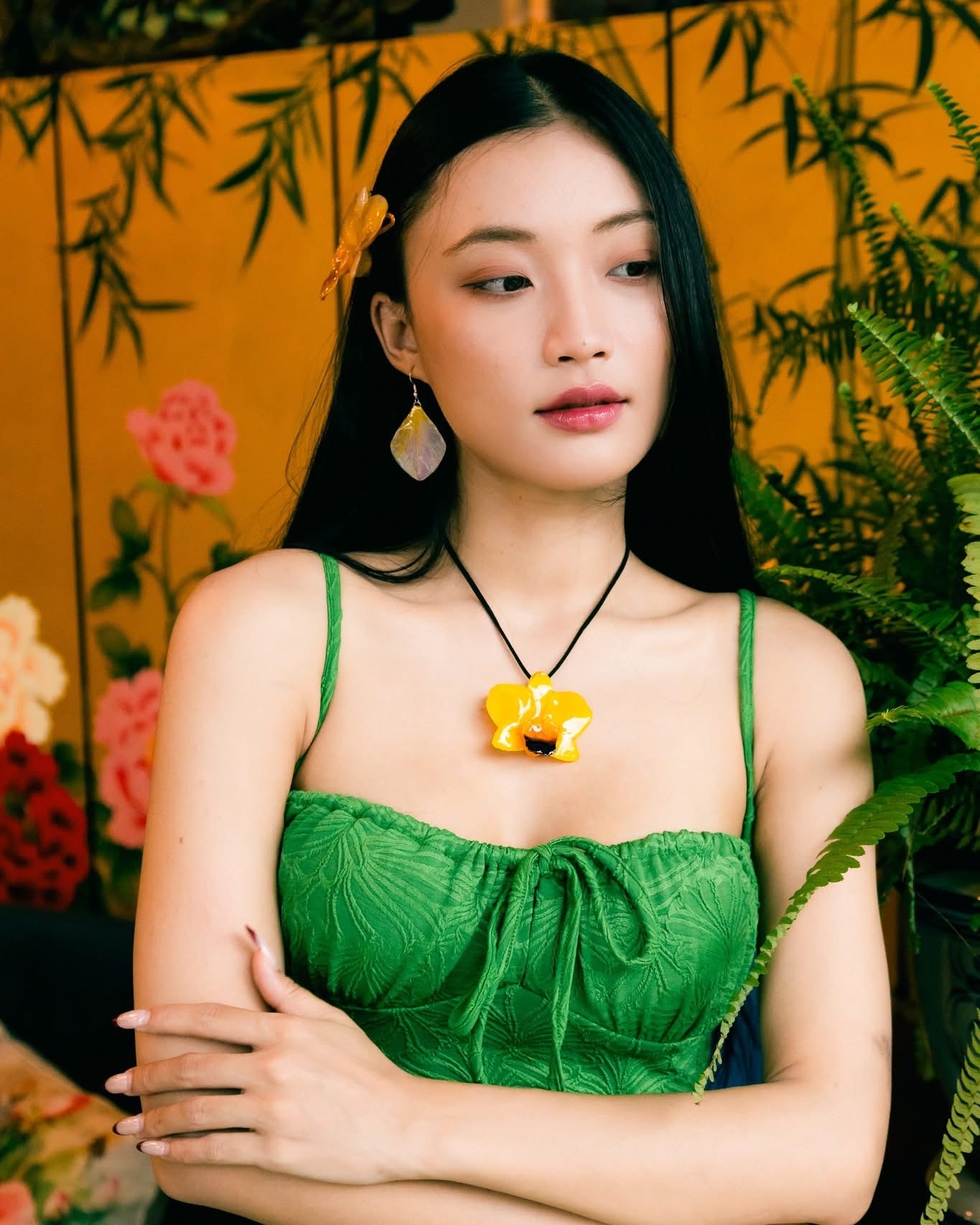 Model wearing a yellow flower necklace with petal earrings and a floral hair accessory