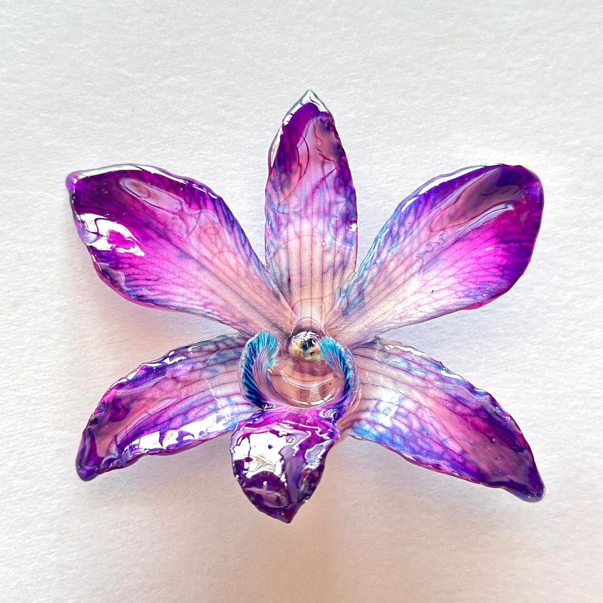 Close-up of a preserved purple flower showing its petal veining and clear finish